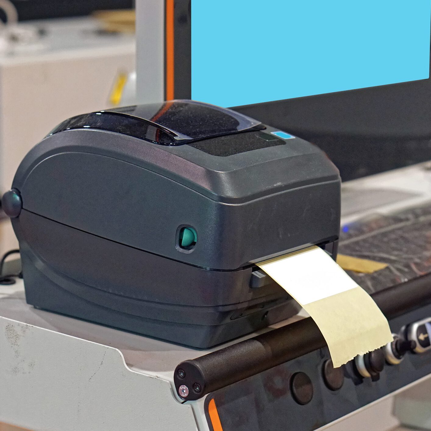 Label printer on a desk with monitor.