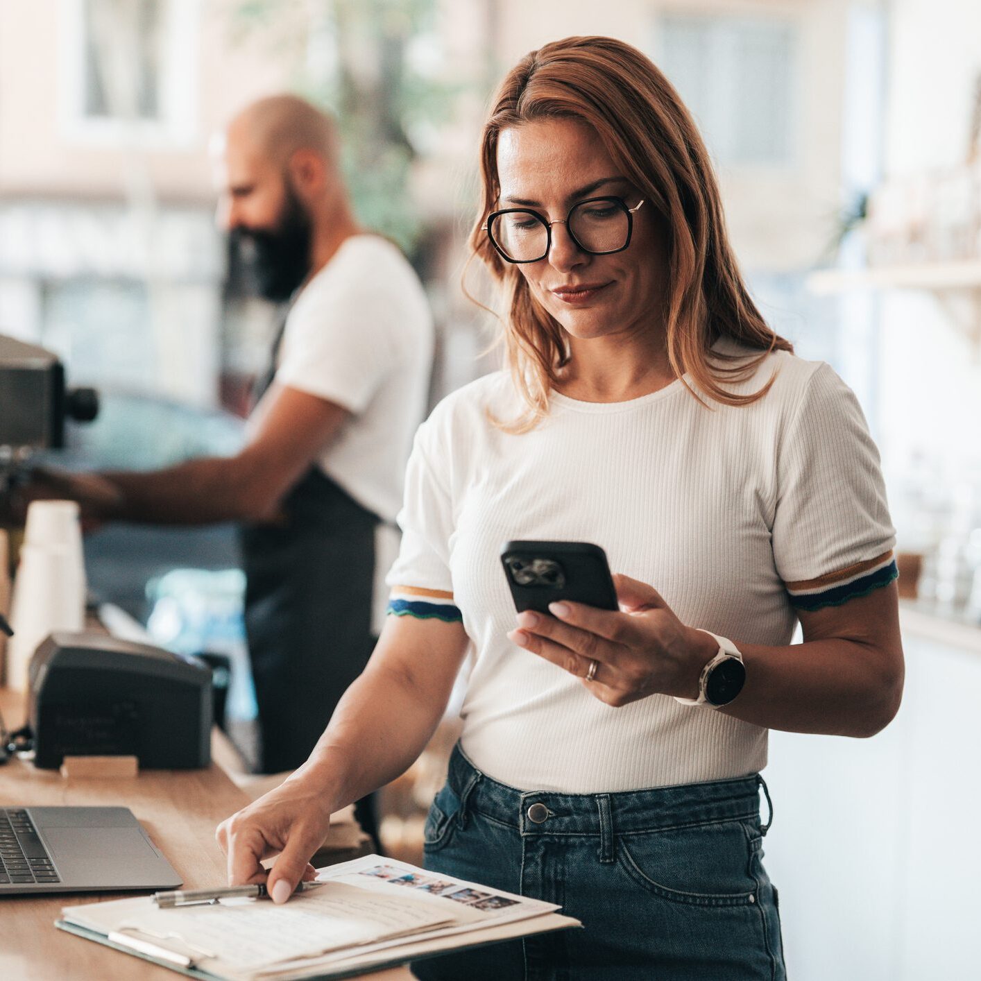 Woman using phone in coffee shop.